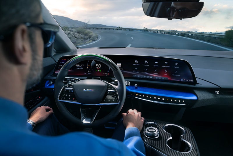 Front View of the 2026 OPTIQ-V Driving Through the Dusk Utilizing its Headlights | C. Harper Cadillac in Belle Vernon PA